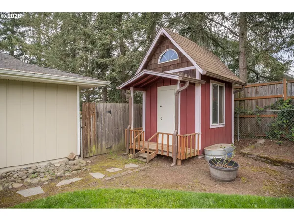 a view of a small house with a small yard and large tree