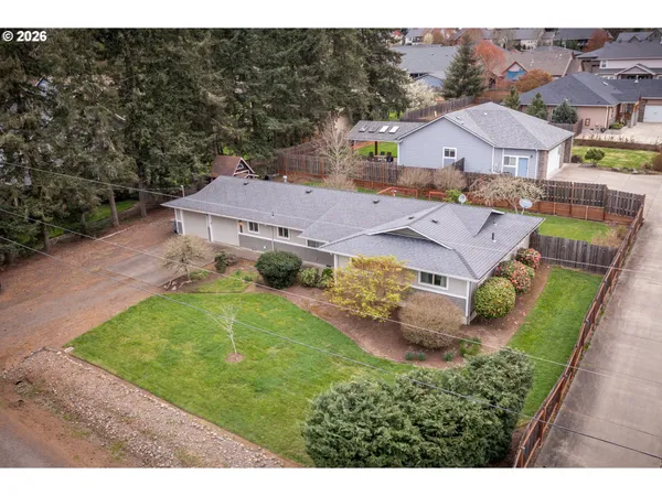 an aerial view of residential houses with outdoor space and parking