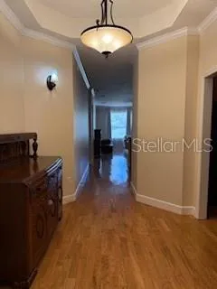 a view of a livingroom with a flesh screen tv and wooden floor