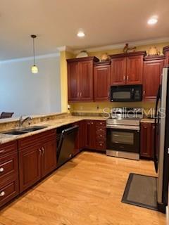 1027 Orca Court Holiday, FL 34691 - Photo 6 of 14 a kitchen with stainless steel appliances granite countertop a stove a sink and a microwave