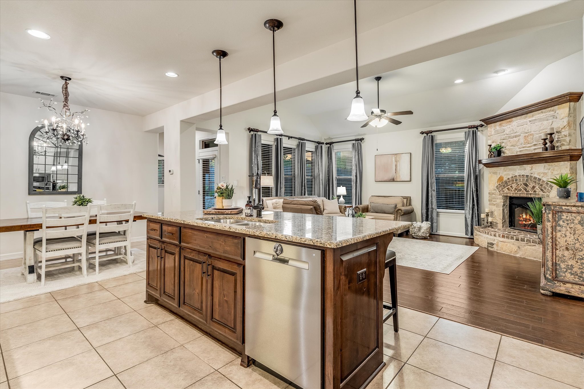 226 Galloway Lane Austin, TX 78737 - Photo 30 of 30 Kitchen featuring open floor plan, stainless steel dishwasher, a kitchen island with sink, a stone fireplace, and a breakfast bar