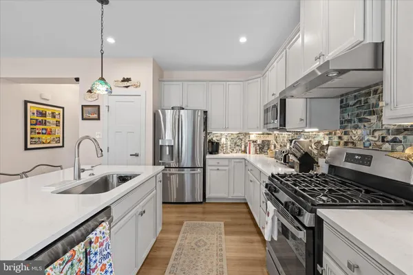 a kitchen with refrigerator a sink and a stove