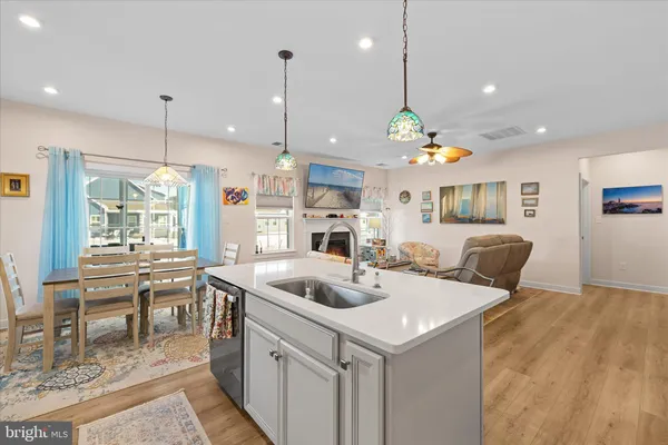 a kitchen with stainless steel appliances granite countertop a sink a stove and a wooden floors