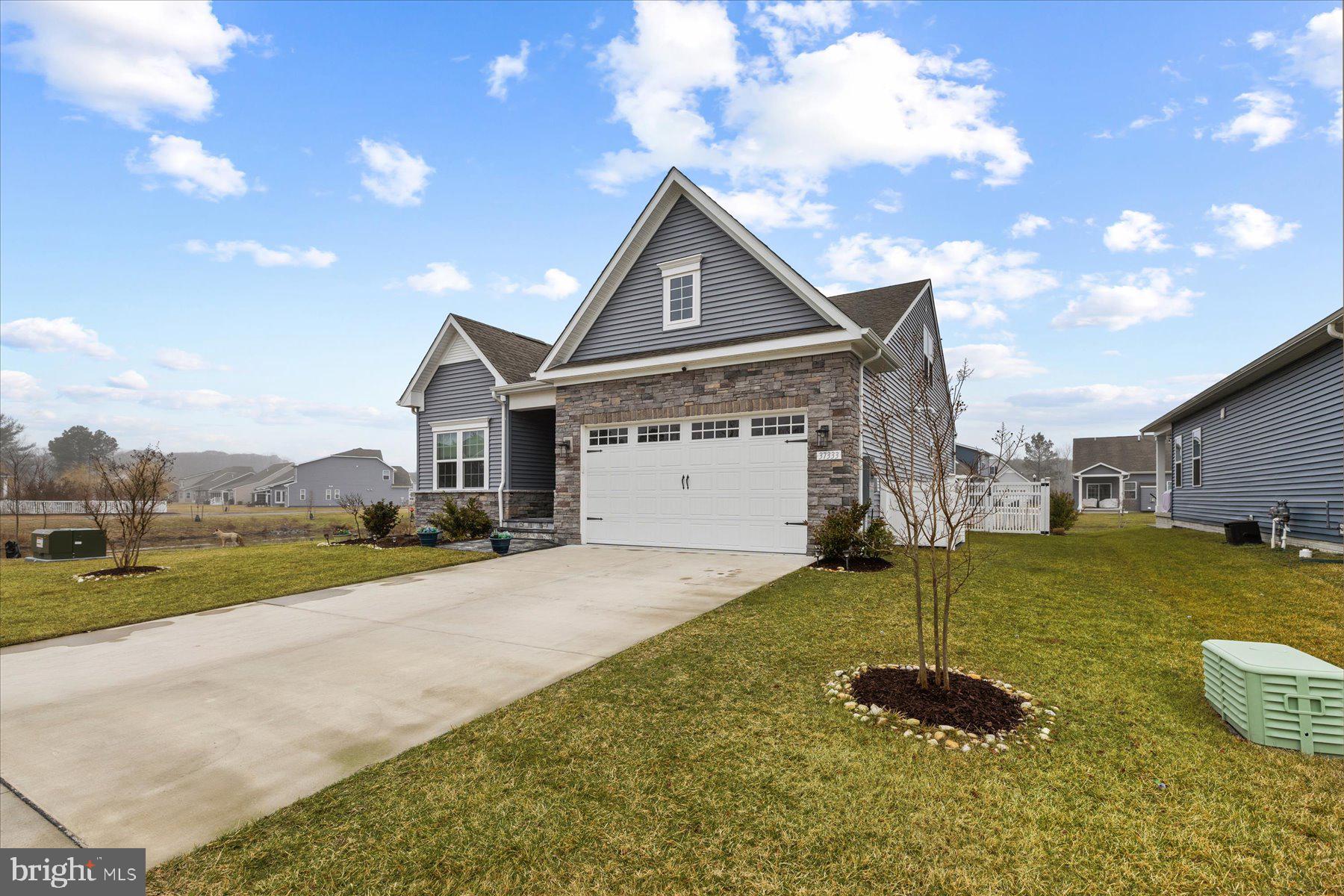 37333 Kestrel Way Ocean View, DE 19970 - Photo 2 of 48 a front view of a house with a yard and garage