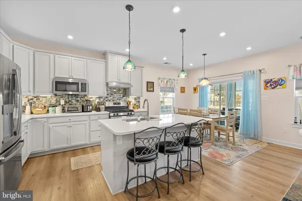 a kitchen with kitchen island a dining table and chairs