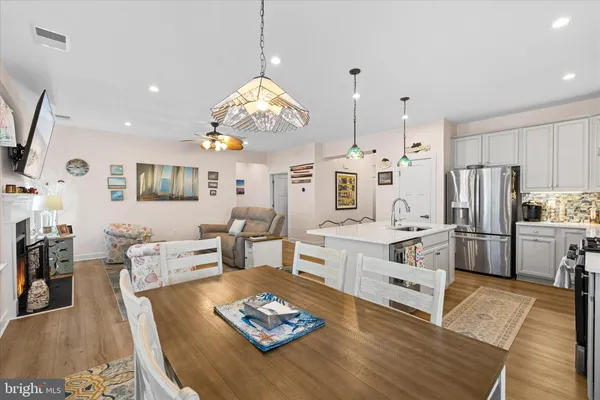 a living room with furniture kitchen view and a wooden floor