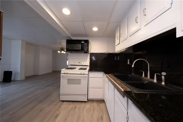 a kitchen with stainless steel appliances a sink a stove top oven a counter space and cabinets