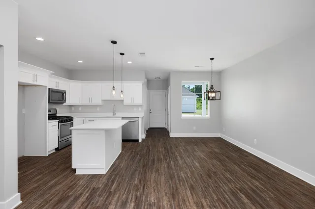 a view of kitchen with sink and refrigerator