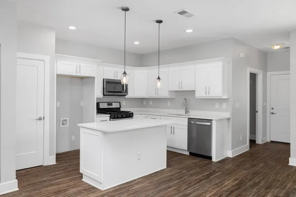 a kitchen with stainless steel appliances granite countertop a stove a sink and a refrigerator