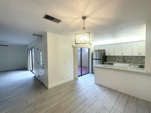 a view of a kitchen with a sink and wooden floor
