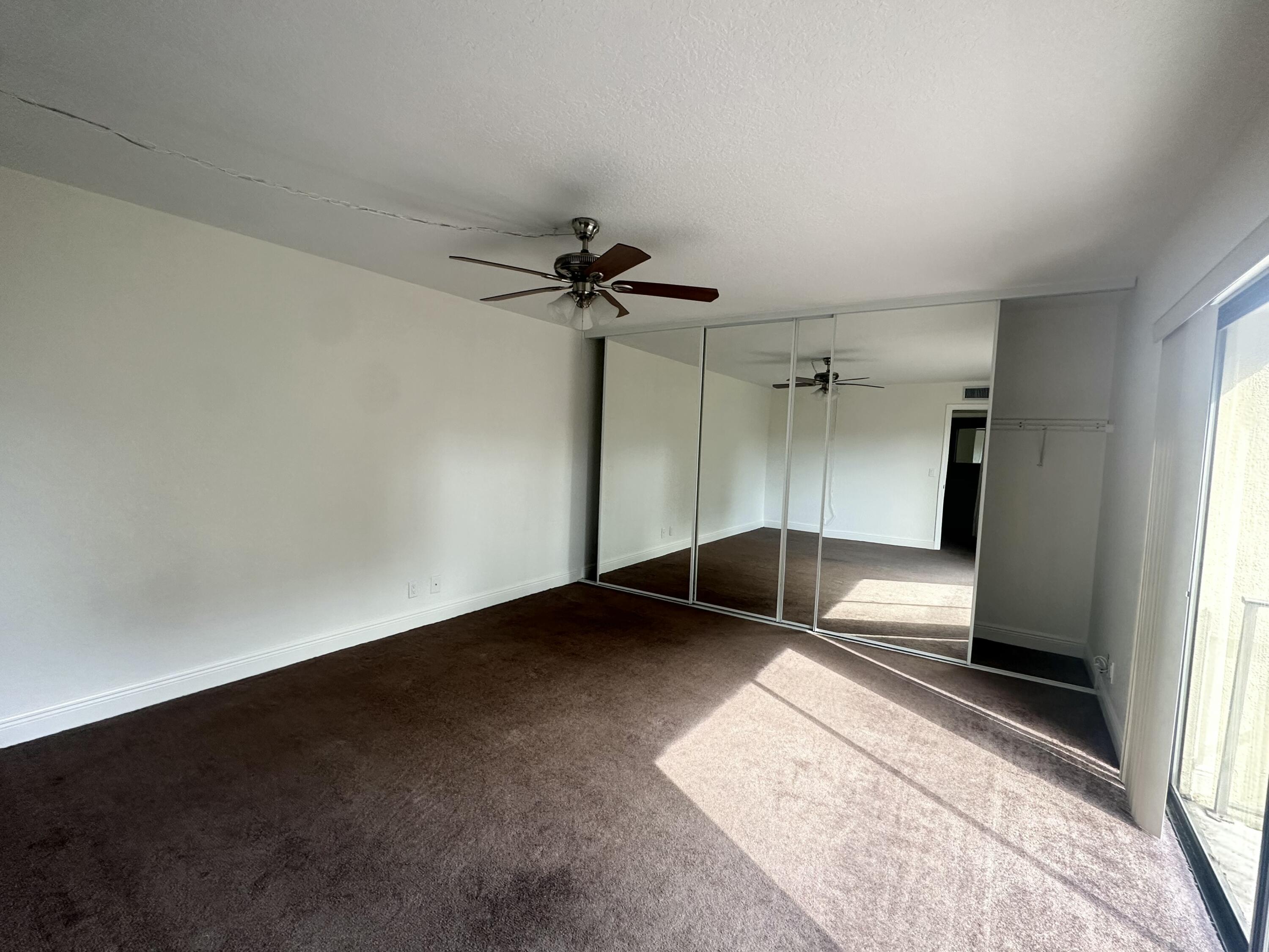 282 Arabian Road Palm Springs, FL 33461 - Photo 18 of 26 an empty room with a ceiling fan and window