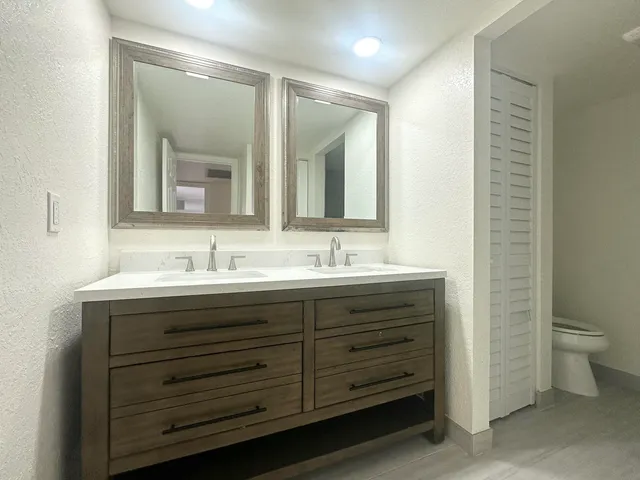 a bathroom with a double vanity sink and a mirror
