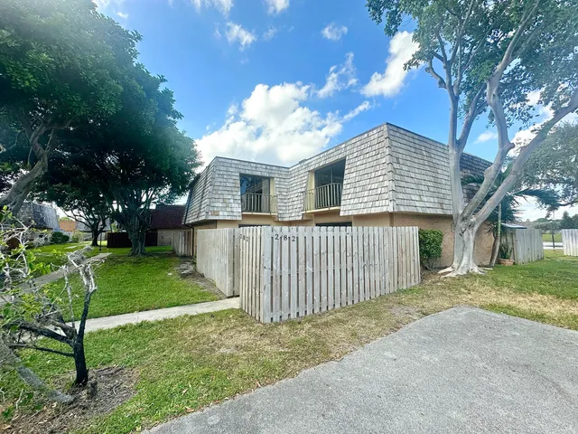 a front view of a house with yard and tree s