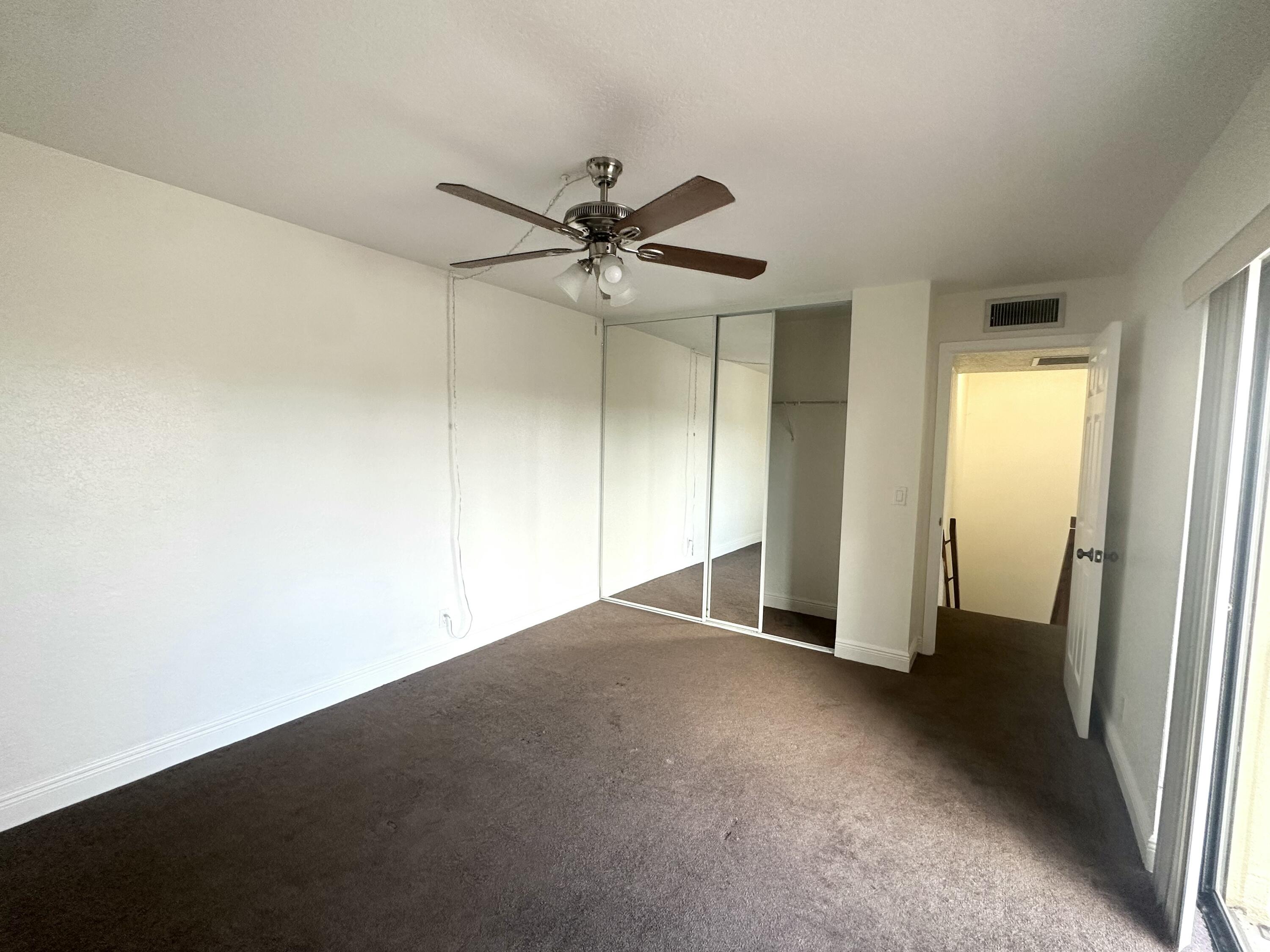 282 Arabian Road Palm Springs, FL 33461 - Photo 24 of 26 an empty room with a ceiling fan and a window