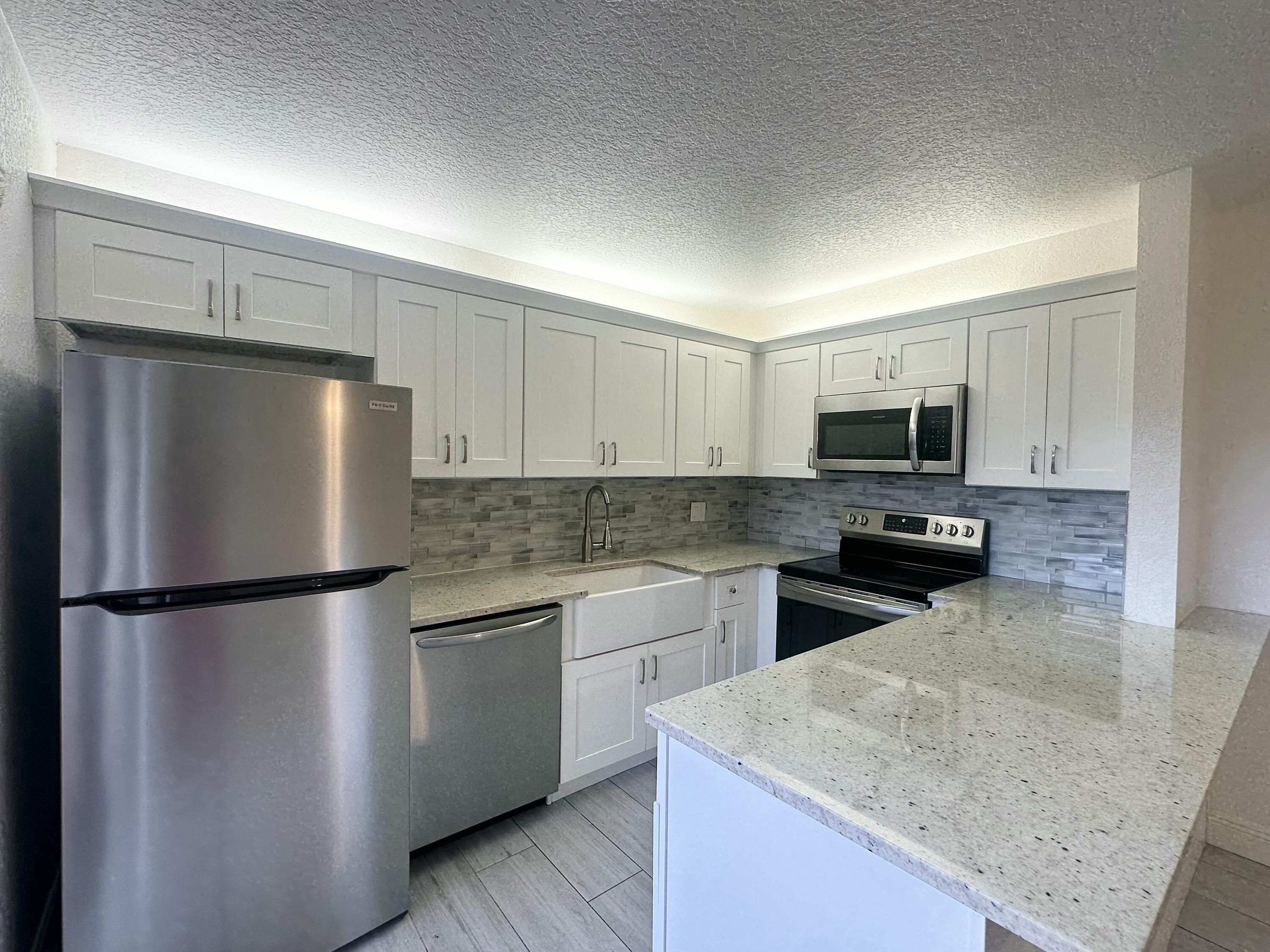 282 Arabian Road Palm Springs, FL 33461 - Photo 7 of 26 a kitchen with a refrigerator sink and microwave
