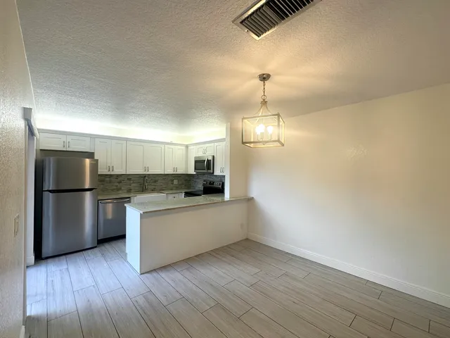 a kitchen with a refrigerator and a stove top oven