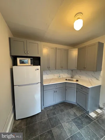 a kitchen with granite countertop a sink a stove and refrigerator