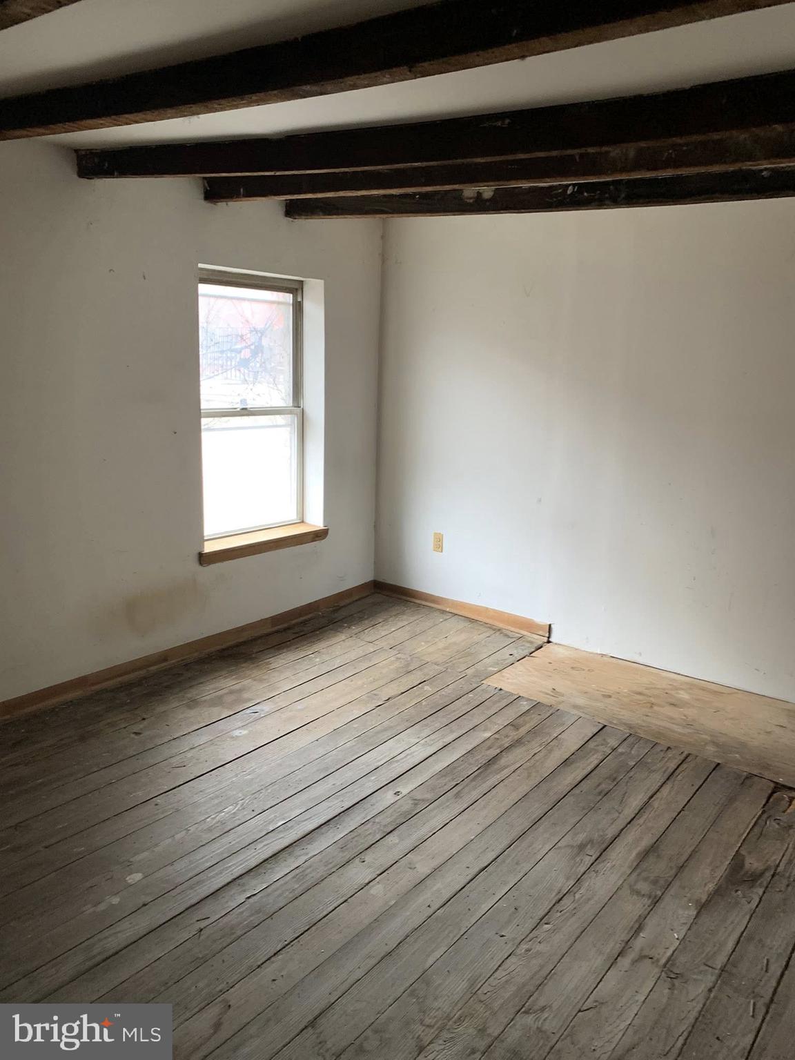 642 Portland Street Baltimore, MD 21230 - Photo 14 of 17 a view of an empty room with wooden floor and a window