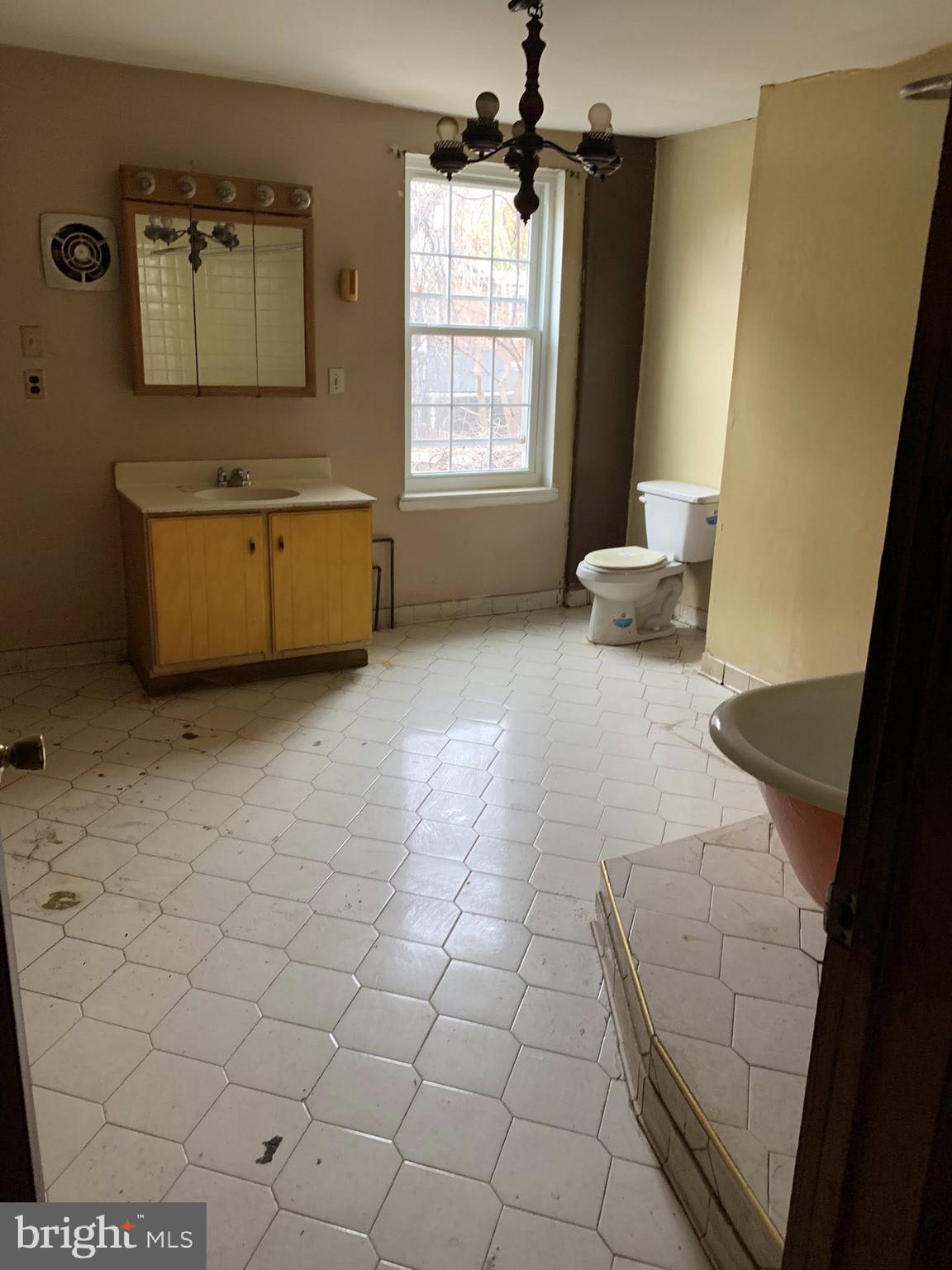 642 Portland Street Baltimore, MD 21230 - Photo 5 of 17 a bathroom with a sink a mirror and a bathtub