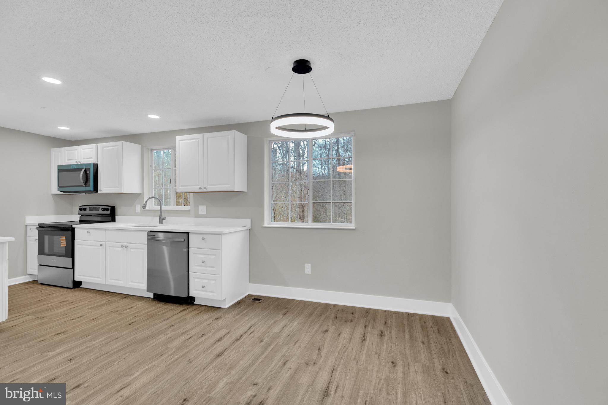 8677 Hickory Ridge Court Springfield, VA 22153 - Photo 13 of 31 a kitchen with a refrigerator and white cabinets