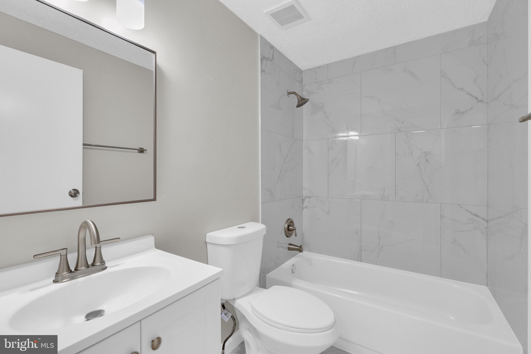 8677 Hickory Ridge Court Springfield, VA 22153 - Photo 23 of 31 a bathroom with a toilet a sink a mirror a bathtub and vanity