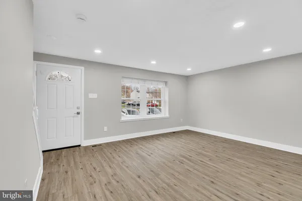 an empty room with wooden floor and window