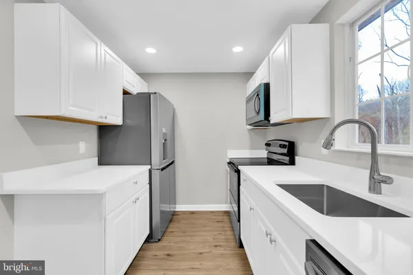 a kitchen with a sink a refrigerator and cabinets