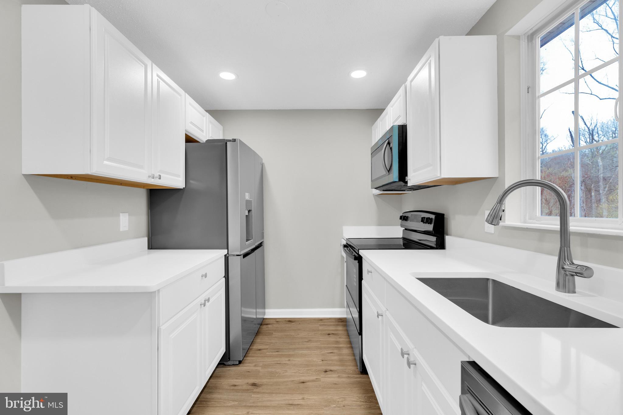 8677 Hickory Ridge Court Springfield, VA 22153 - Photo 10 of 31 a kitchen with a sink a refrigerator and cabinets