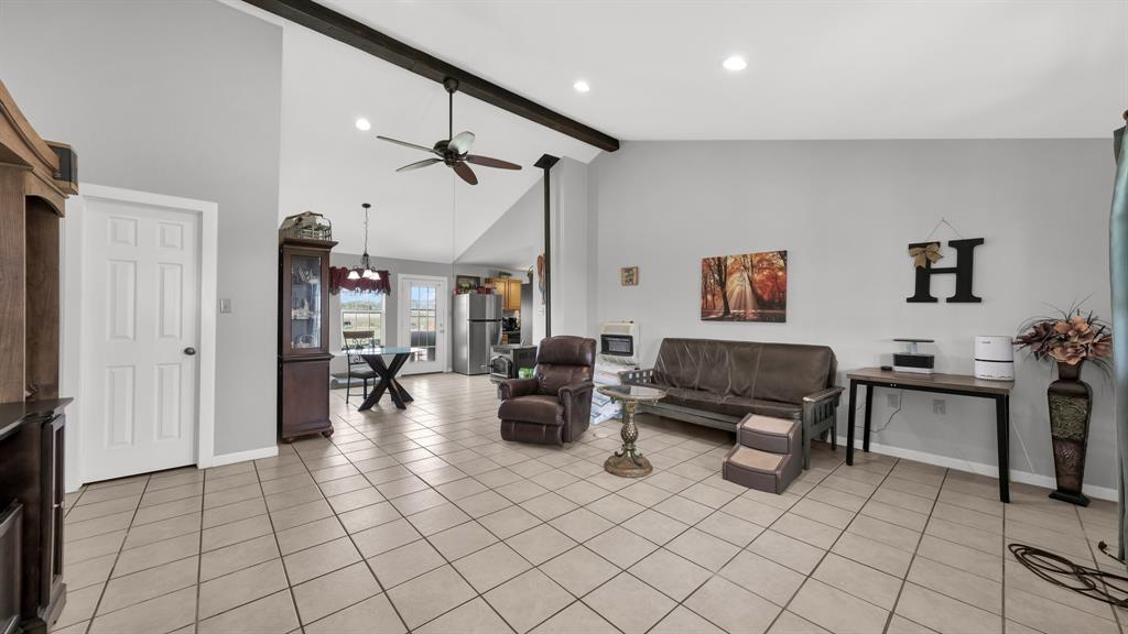11500 Bowden Road Lipan, TX 76462 - Photo 20 of 32 Tiled living room with beam ceiling, ceiling fan, and high vaulted ceiling
