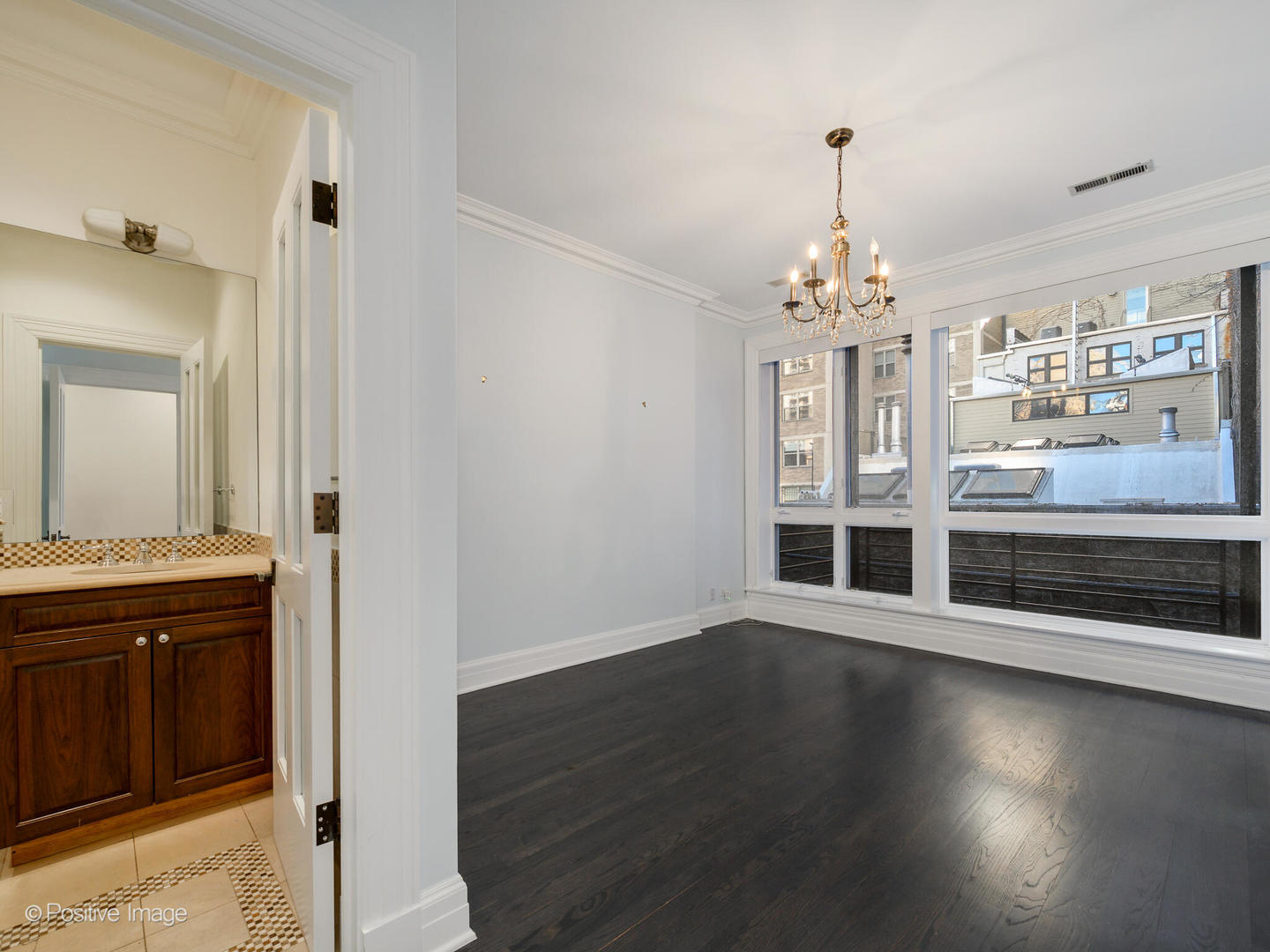 37 East Elm Street Chicago, IL 60611 - Photo 22 of 32 an empty room with wooden floor and staircase