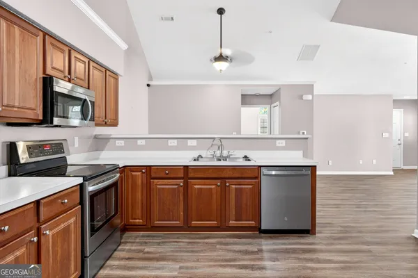 a kitchen with stainless steel appliances granite countertop a sink and stove top oven