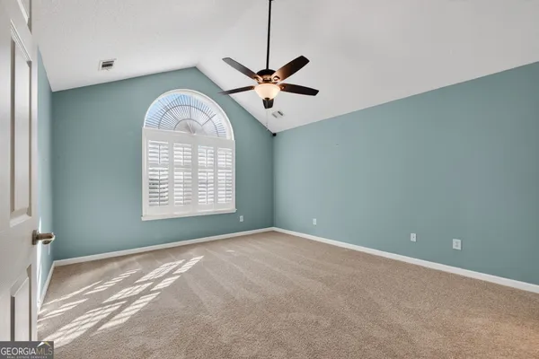 a view of a room with a ceiling fan and a window