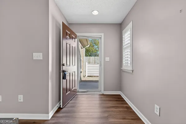 a view of a hallway with wooden floor and stairs