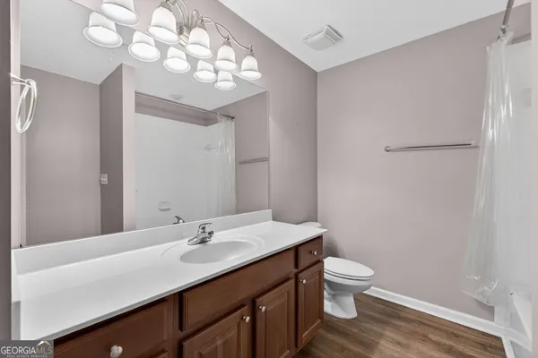 a bathroom with a granite countertop sink a toilet and a mirror