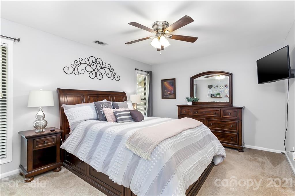5063 Suwarrow Circle Tega Cay, SC 29708 - Photo 13 of 18 a bedroom with a bed and a chandelier
