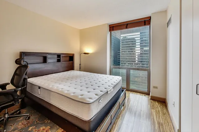 a bedroom with a bed and wooden floor