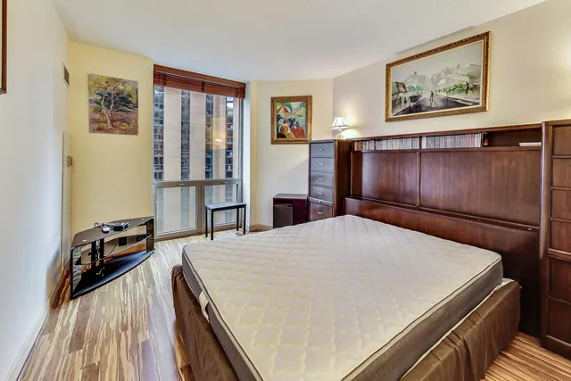 a room with a bed and painting on the wall