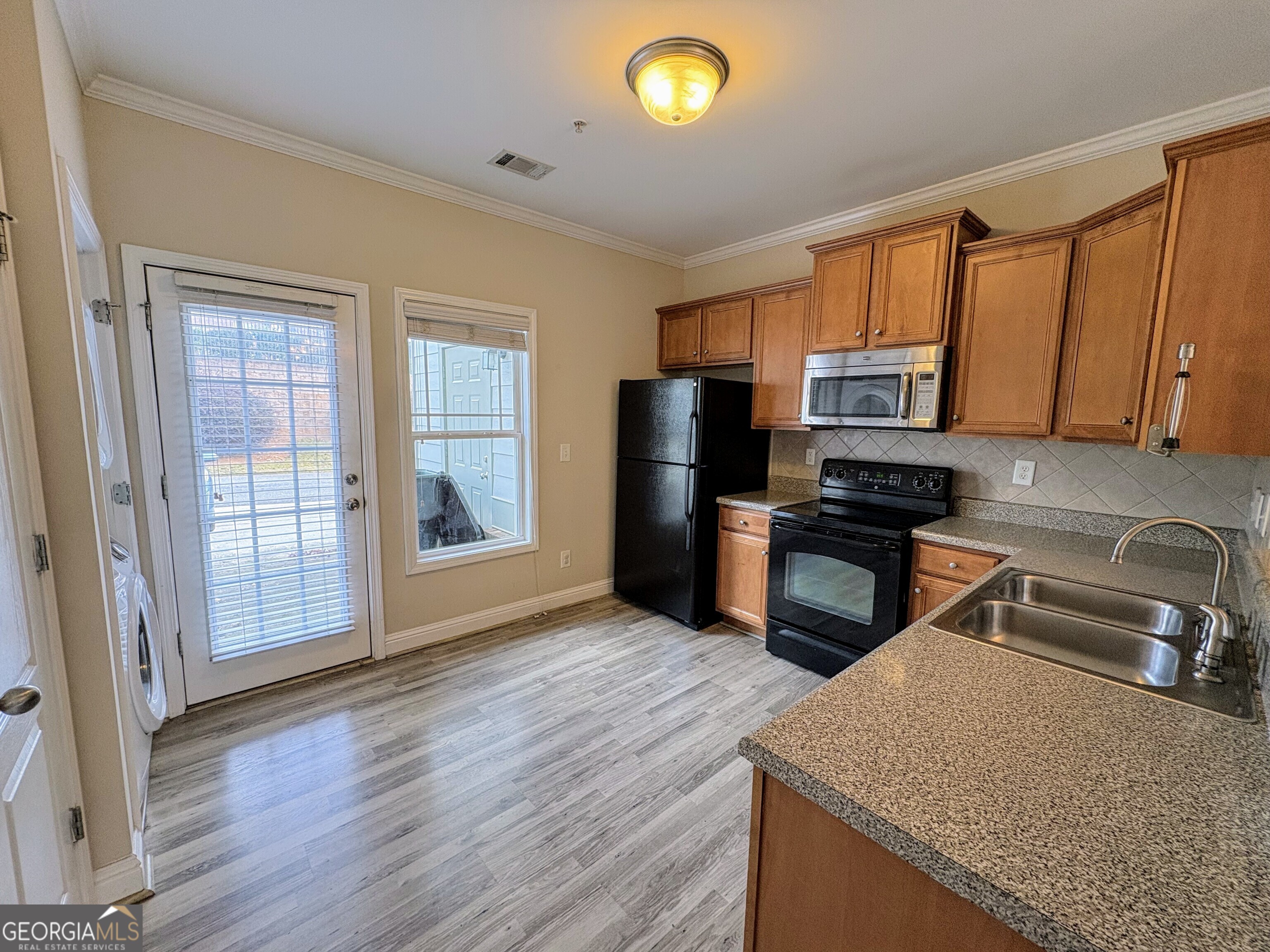 135 Oconee River Circle Athens, GA 30605 - Photo 4 of 17 a kitchen with granite countertop wooden cabinets a stove and a sink