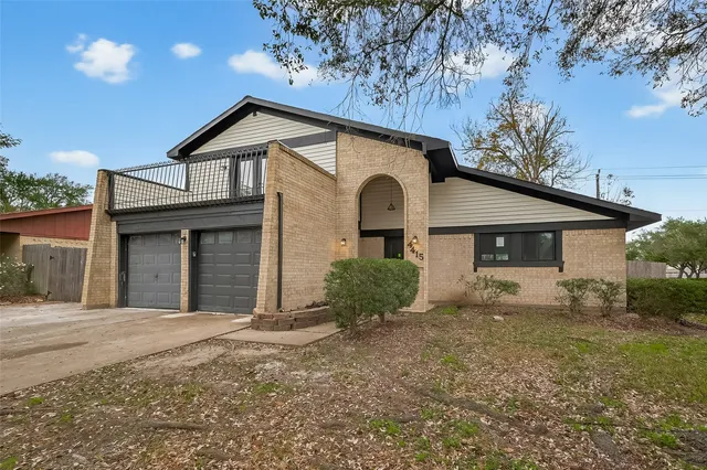a view of a house with a yard and large tree