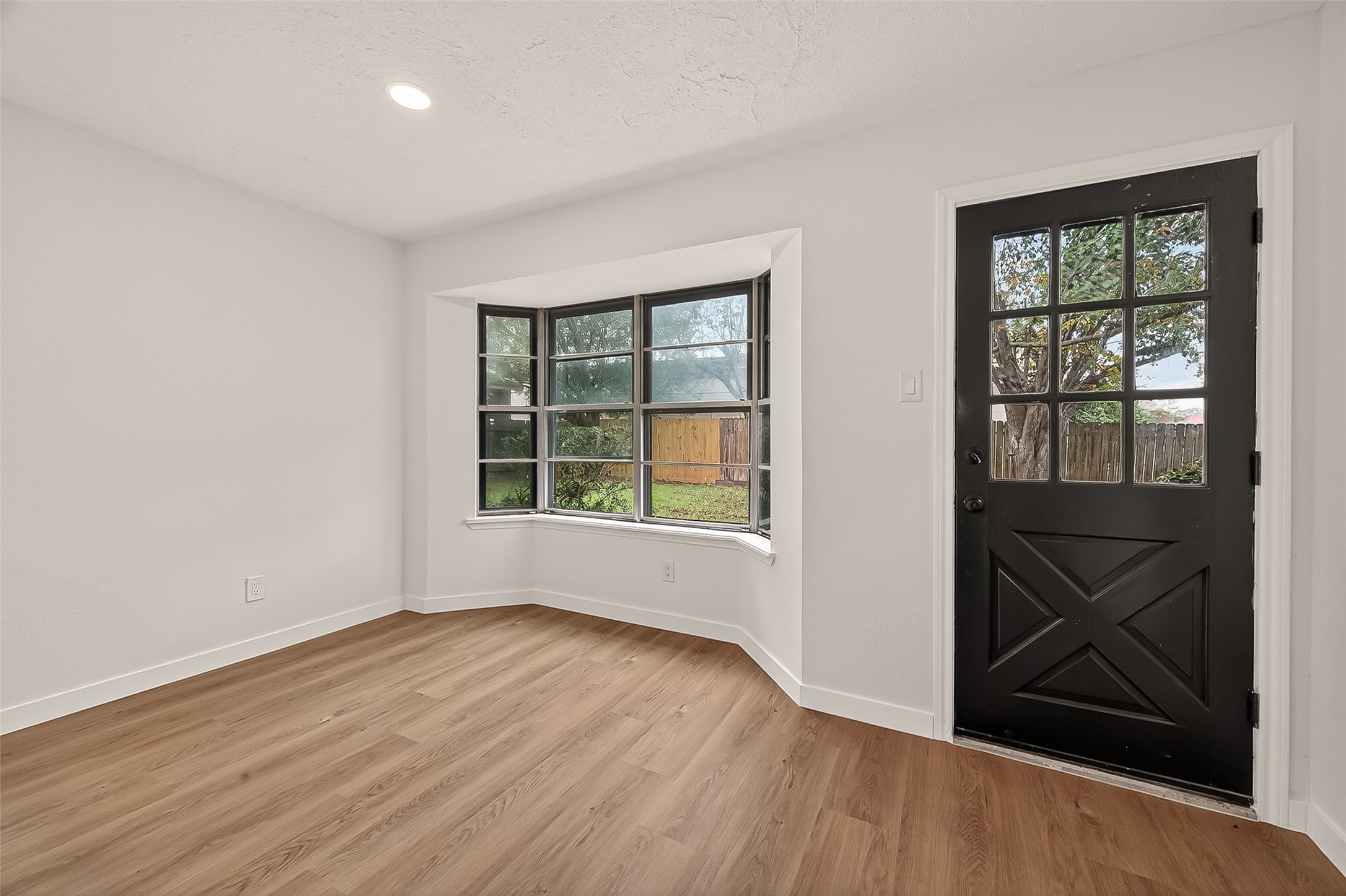 4415 Anacacho Street Pasadena, TX 77504 - Photo 14 of 45 an empty room with wooden floor and windows