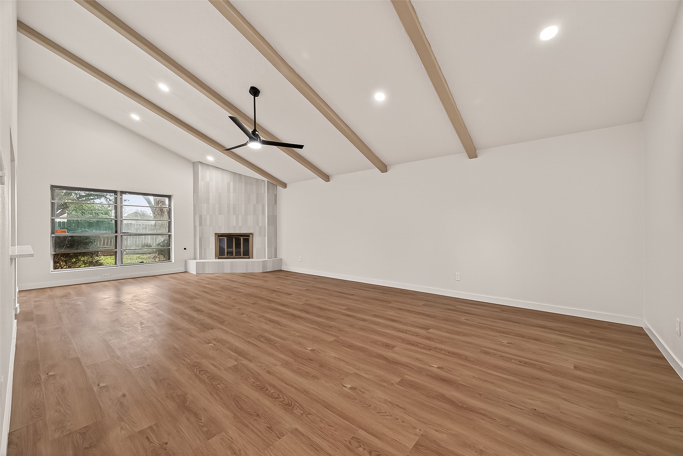 4415 Anacacho Street Pasadena, TX 77504 - Photo 7 of 45 an empty room with wooden floor ceiling fan and windows