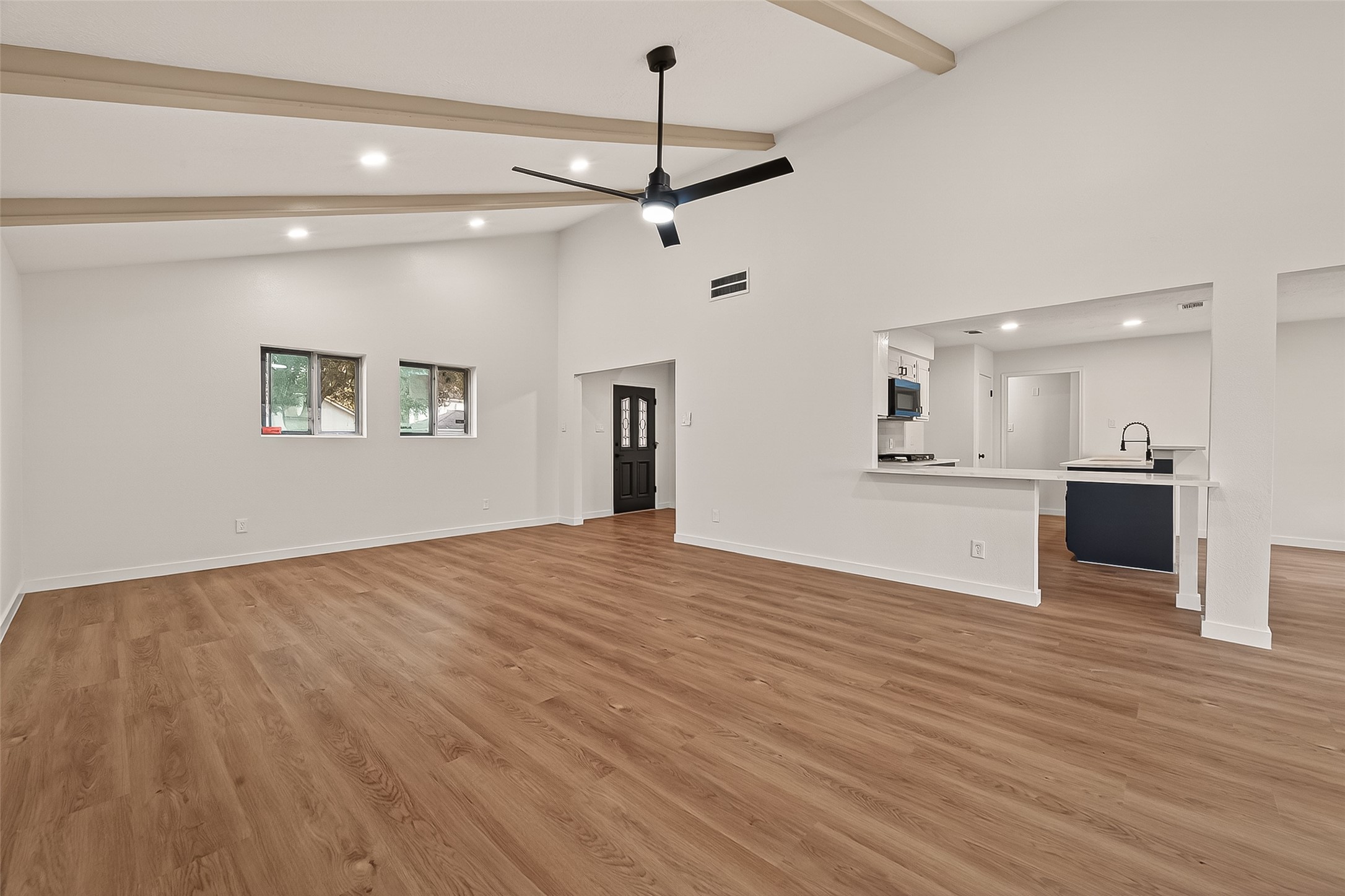 4415 Anacacho Street Pasadena, TX 77504 - Photo 9 of 45 a view of an empty room with wooden floor and a kitchen