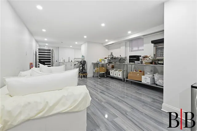 a living room with furniture kitchen view and a wooden floor