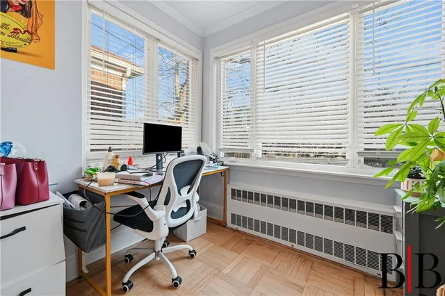 a view of a workspace with furniture and a window