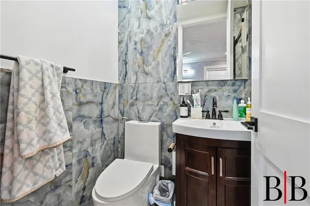 a bathroom with a toilet sink and mirror