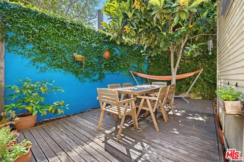 a patio with wooden floor and outdoor seating