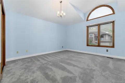 an empty room with windows and chandelier