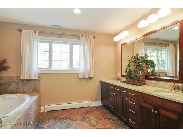 14 West Sunset Road Chicago, IL 60647 - Photo 13 of 25 a bathroom with a tub a sink double vanity and a mirror