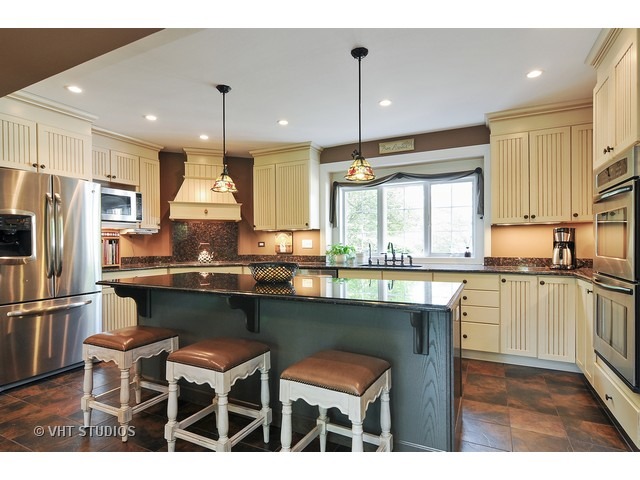 14 West Sunset Road Chicago, IL 60647 - Photo 3 of 25 a kitchen with stainless steel appliances granite countertop a table chairs sink refrigerator and microwave