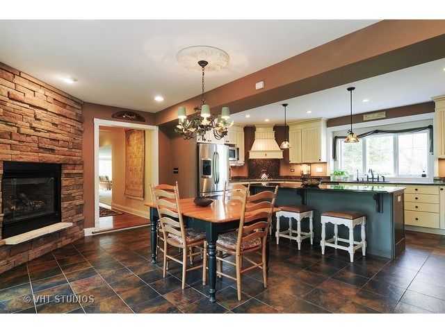 14 West Sunset Road Chicago, IL 60647 - Photo 4 of 25 a dining room with stainless steel appliances kitchen island granite countertop a dining table chairs and granite counter tops